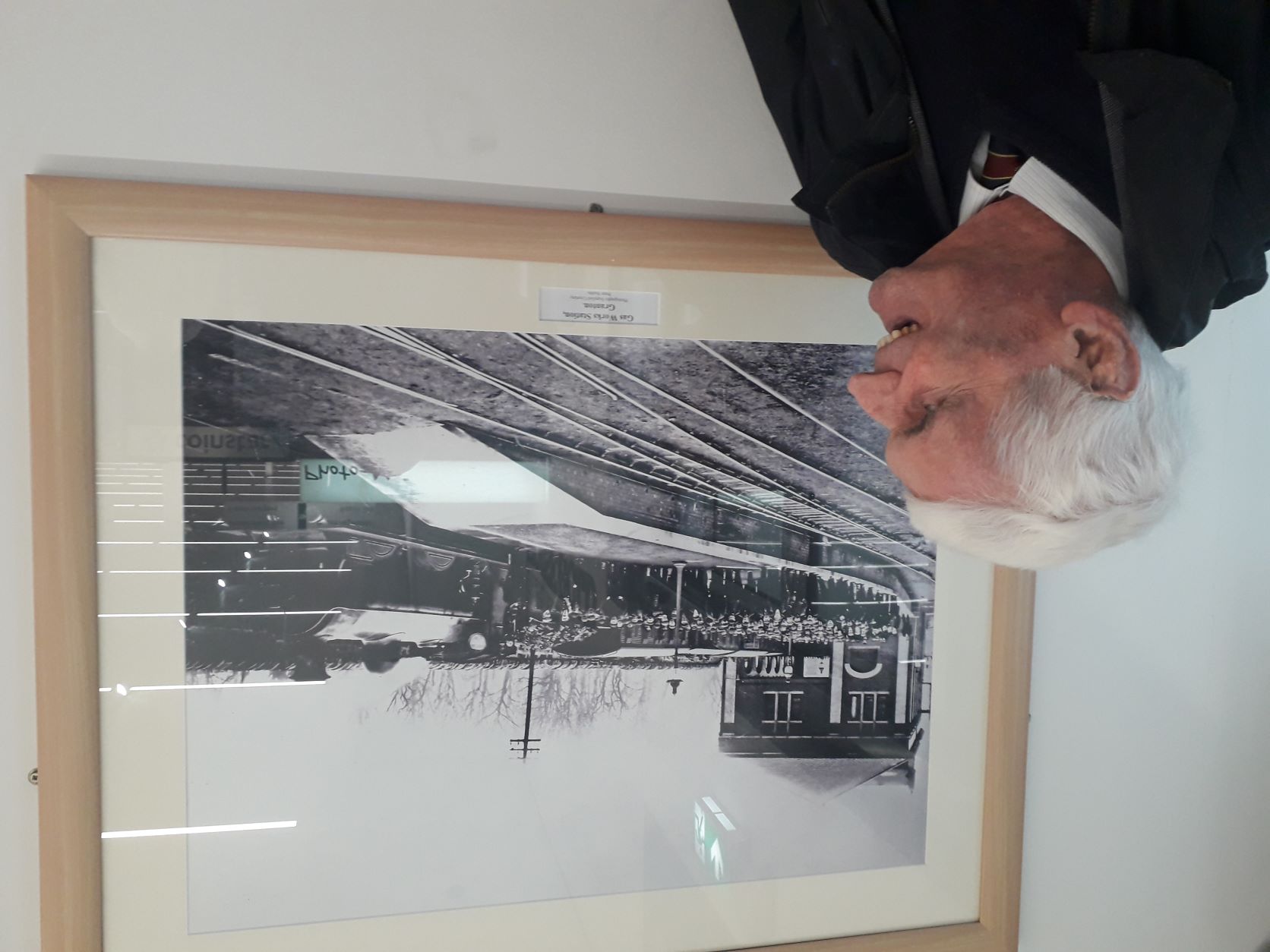 John Cameron OBE studies photo of the original opening ceremony